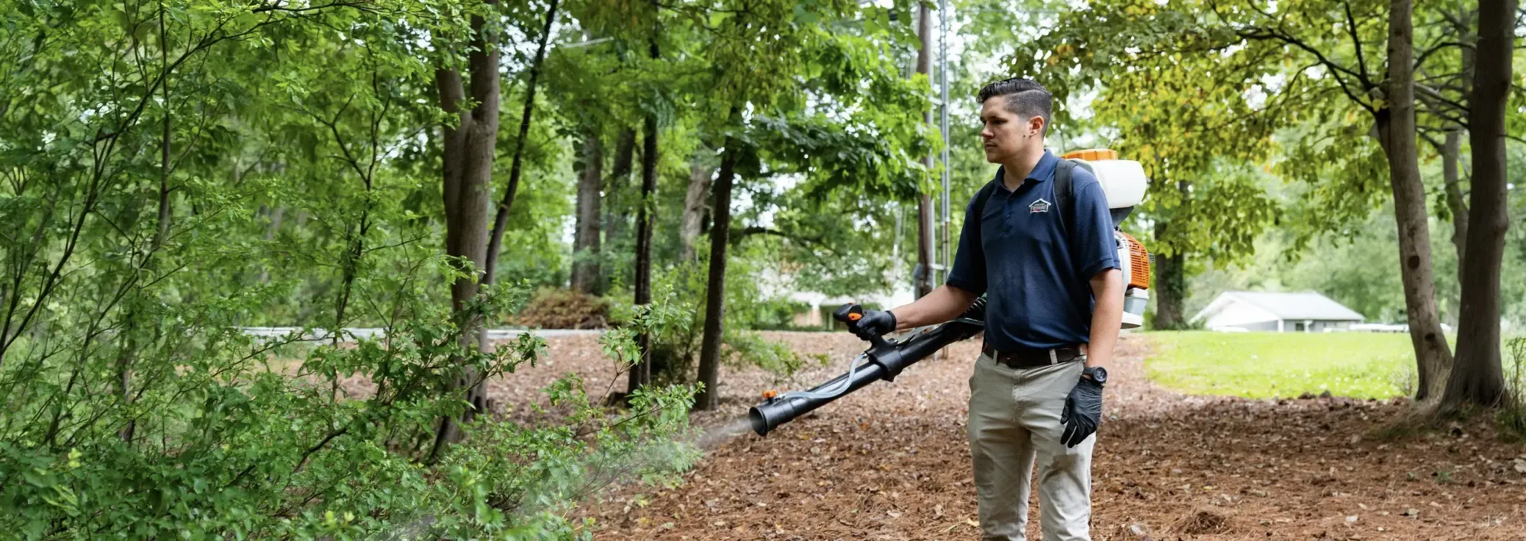 Technician spraying for mosquitoes outside