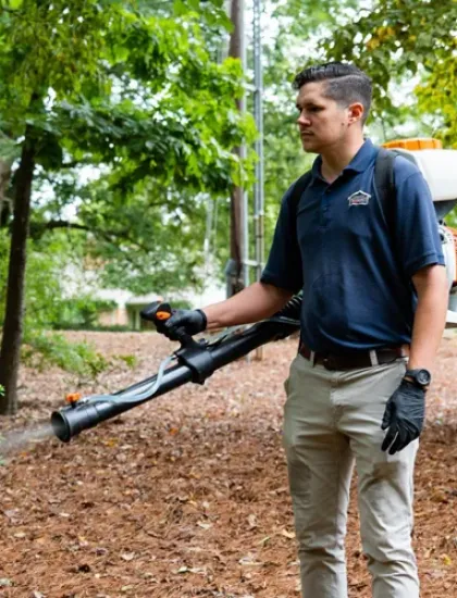 technician spraying for mosquitoes outside